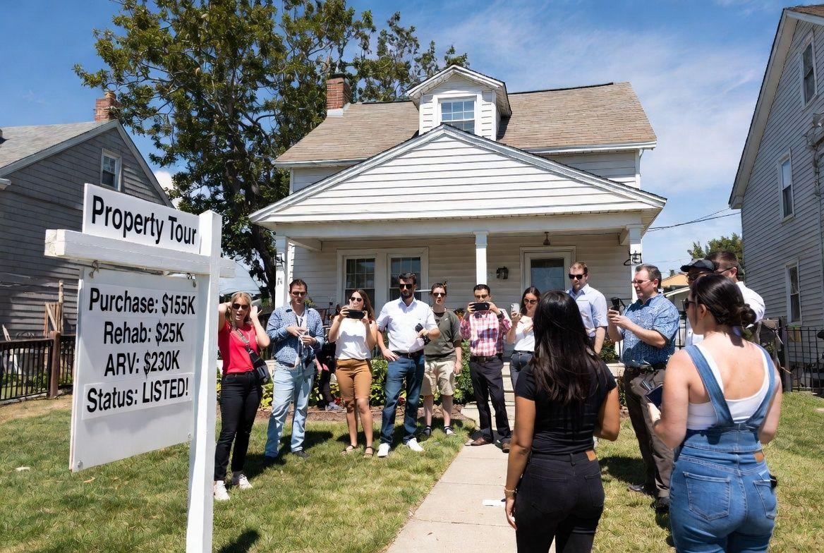 A group gathering outside a property during an educational tour
